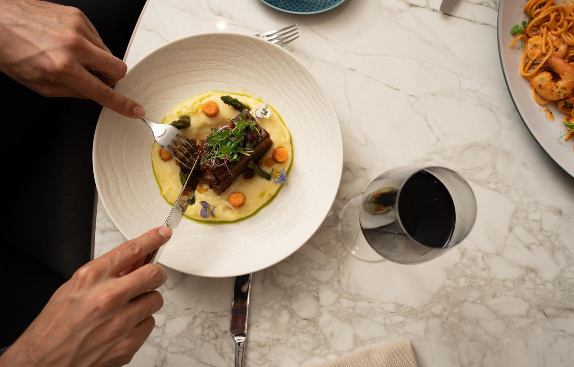 Hotel Address Istanbul Exterior foto A person using a fork to cut into a meal